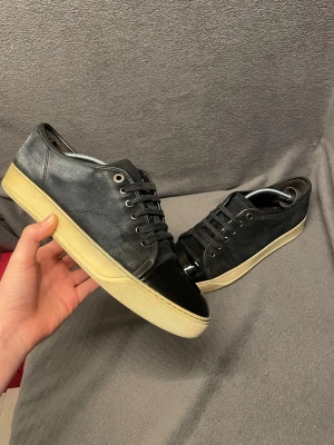 Lanvin Cap toe - Snygga marinblå sneakers från Lanvin med mocka och en glensig Cap toe på framsidan. Skorna har inga skador. Skick kan man se i bilderna. Storlek 41 passar även 42. Nypris runt 5000.                                                                      Skriv vid frågor, pris kan diskuteras 🤝