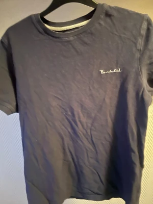 Mörkblå t-shirt från Bondelid - Snygg mörkblå t-shirt från Bondelid med diskret broderad logga på bröstet. Klassisk passform och rund halsringning, perfekt för en stilren och enkel look. Tillverkad i mjuk bomull som känns skön mot huden.