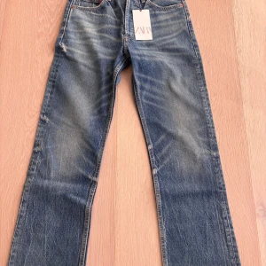 Blå boyfriend jeans från Zara, stl 32 - Snygga blå boyfriend jeans från Zara med låg midja och raka ben. Jeansen har klassisk femficksdesign, slitningar och en cool tvättad look. Det är helt nya med lappat kvar🩷