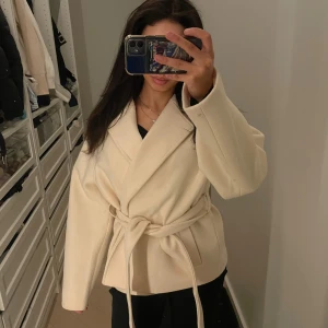 Beige kappa med bälte från Gina Tricot - Säljer en beige kappa från Gina Tricot i storlek S. 