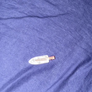 Vit hårklämma med pärlemorskimrande yta - Säljer en liten hårklämma i vit pärlemor-look med metallspänne. Perfekt accessoar för att hålla undan luggen eller piffa till frisyren. Klämman har en mjukt avsmalnande form och reflekterar ljuset snyggt.