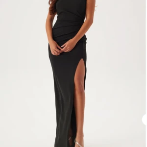 Svart långklänning med slits XS - Supersnygg svart långklänning med fyrkantig halsringning och hög slits på ena sidan. Använd en gång!