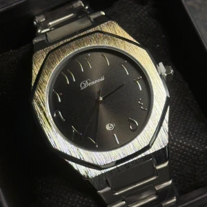Silverfärgad klocka från Denvoosi - Stilren klocka från Denvoosi med borstad silverfärgad boett och armband i metall. Svart urtavla med arabiska siffror och datumvisning vid klockan sex. Klockan har en modern, kantig form och klassisk länk i metall.