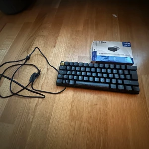 D-Link AC1300 MU-MIMO Wi-Fi Nano USB Adapter med hyperX alloy orgins 60 - D-Link AC1300 MU-MIMO Wi-Fi Nano USB Adapter i originalförpackning. Perfekt för snabb och stabil trådlös anslutning via USB 2.0. Produkten ser ut att vara i gott skick, kartongen är något sliten men adaptern är komplett.