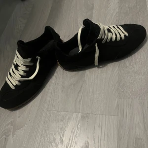 Svarta sneakers Axel Arigato mocka - Säljer mina snygga Arigatos som har ett riktigt bra fint skick, modellen heter Daze Runner dom kostar 2700kr i nypris och är i storlek 41 men passar 42. Pris går diskuteras.