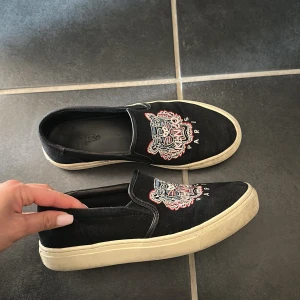 Svarta Kenzo slip-on sneakers - Svarta slip-on sneakers från Kenzo med ikoniskt broderat tigerhuvud i flera färger på ovandelen. 