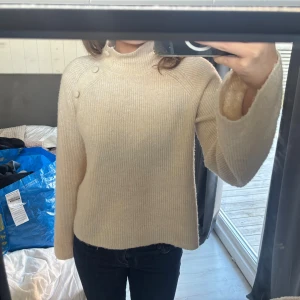 Vit polotröja med knappar - Säljer min super fina vita stickade tröja med hög hals och snygga knappar längs axeln🙏🏽