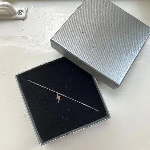 Edblad halsband  - Snyggt och minimalistiskt halsband i silverfärgad metall med en liten blixt som hänge.Perfekt för dig som gillar stilrena detaljer och vill ha något unikt runt halsen.
