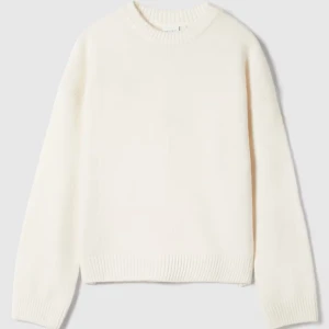 Ljus stickad tröja - Mysig vit stickad tröja med rund halsringning och ribbade muddar. Tröjan har en avslappnad passform och långa ärmar, perfekt för lager-på-lager under kyliga dagar. Enkel och stilren design som funkar till allt.