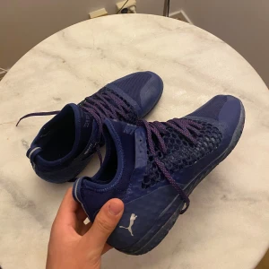 Snygga Puma Future 19.4 Netfit inomhusskor – Grymt sköna & lätta! - Säljer ett par riktigt snygga Puma Future 19.4 Netfit i mörkblått med lila snören. Supersköna skor som sitter perfekt på foten tack vare Netfit-snörningen – du kan själv justera passformen precis som du vill. Passar perfekt till inomhusfotboll, futsal eller träning. Om det är någon du funderar efter är det bara och kontakta mig!