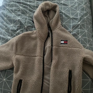 Tommy Hilfiger sherpa jacka/hoodie - Skitsnygg, varm och bekväm jacka av Tommy Hilfiger i sherpa material. perfekt för kallare årstider. knappt använd då den är för stor för mig, nypris runt 1300kr. pris kan diskuteras . stor i storleken känns som en L