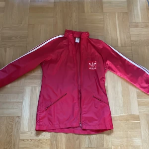 Röd Adidas jacka  - Röd adidas jacka som jag aldrig använt och är i storlek 38.