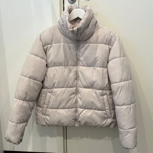 Ljusbeige pufferjacka från 157 XS - ljusbeige pufferjacka från 157 i storlek XS. hög krage, dragkedja framtill och två fickor på sidorna. mysig och varm till vintern 🩷🩷