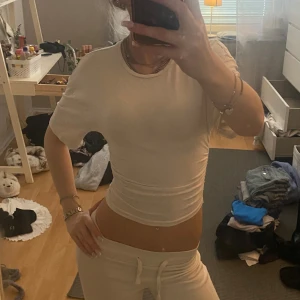 Vit tight t-shirt från Gina Tricot - Säljer en vit, tight och croppad t-shirt från Gina Tricot. T-shirten har korta ärmar och rund halsringning. Enkel och stilren modell som sitter figurnära och är perfekt till jeans eller mjukisbyxor.