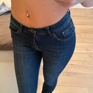 Mörkblå skinny jeans - Helt oanvända. Snygga mörkblå skinny jeans med klassisk femficksdesign och hög midja. Jeansen har smal passform och är tillverkade i stretchigt denim som sitter tajt och bekvämt. Perfekt för dig som gillar en modern och stilren look.