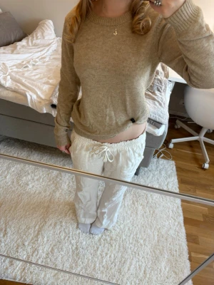 Beige stickad tröja från Vila - Säljer en beige stickad tröja från Vila med rund hals och långa ärmar. Tröjan har ribbade muddar vid ärmslut, hals och nederkant. Perfekt för lager-på-lager och chill dagar. Passar dig som gillar enkel och stilren design. 🤍🤍