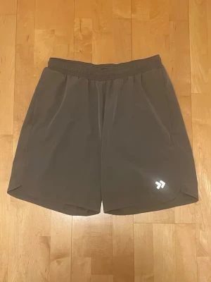 Grå träningsshorts från Lager 157 strl XL - Säljer ett par grå träningsshorts från Lager 157 i storlek XL. Märket på framsidan har reflex. Har två stycken sidofickor. Shortsen är i mycket bra skick. Färgen är ren grå i verkligheten.