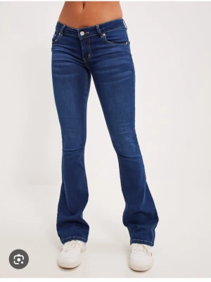 Lågmidjade mörkblå utsvängda jeans Nelly - Helt slutsålda. Strl 38 passar även 36 de är mycket stretchiga och formar sig fint efter kroppen, gott skick 