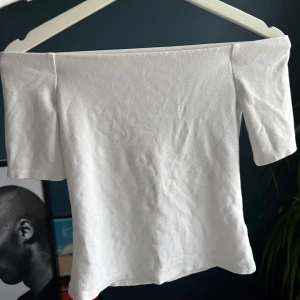 Vit offshoulder topp - Säljer en stilren vit offshoulder topp i mjukt material. Perfekt för dig som vill ha en enkel men snygg topp till sommaren. Passar till både jeans och kjol. Använd fåtal gånger