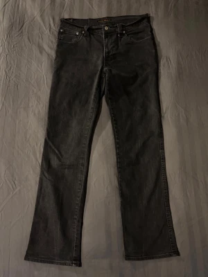 Nudie jeans slim jim bootcut svarta - Tja säljer ett par svarta nudie jeans i riktigt bra skick. Modellen heter slim jim och den sitter slim med lite bootcut. Storlek på lappen är 33/32 men sitter mer som W32 L32