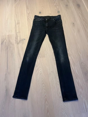 Nudie jeans high Kai - Ett par mörk blåa Nudie Jeans i modellen high Kai. Perfekt för dig som vill ha ett par bekväma och snygga jeans med hög kvalitet och tajtare passform. Dem är i bra skick och har storleken w32 L34
