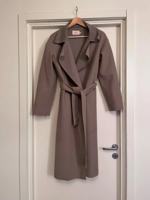 NELLY Filtad kappa  - Kappa från NELLY i filtat material. Sitter jättesnyggt och är ovanligt varm för att vara tunn och lätt. Tråkigt att materialet noppar mycket så det gäller att ha en noppmaskin ☺️Skön och varm till våt-höst. Storlek XS men passar upp till M. Bra skick! Säljs på flera sidor, först till kvarn. 