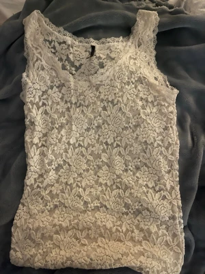 Vit spetslinne från Soyaconcept - Säljer ett vitt linne från Soyaconcept med blommigt spetsmönster. Toppen är ärmlös och har breda axelband samt Materialet är mjukt och genomskinligt, perfekt för lager-på-lager eller som statement-piece. Osäker på storlek men skulle gissa på xs-s. Säljer för 200kr! Köp genomförs endast genom swish. Frakten blir mellan 20-30kr❣️PRIS KAN DISKUTERAS 