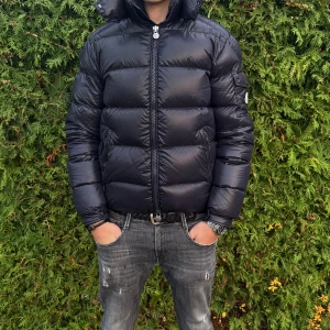 Moncler maya mörkblå - Säljer nu denna maya i storlek 3(M). Jackan är i så gott som nytt skick, och är perfekt nu inför vintern. Har inget tillbehör som tyder på äkthet, men de som vet ser att den är äkta samt går Q/C och tagen att scanna. Hör av er vid frågor Mvh WH 