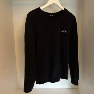 Svart tröja från A.P.C. - Säljer nu en riktigt fet svart tröja från A.P.C. med diskret logga på bröstet. Klassisk rund halsringning och långa ärmar. Tröjan är i storlek L och är i jättebra skick. Om du har frågor om något är det bara att skriva!