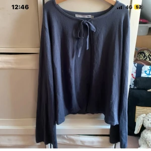 Mörkblå kofta med knyt från 157 - Mysig mörkblå kofta från 157 med långa ärmar och knyt framtill vid halsen. Koftan har en loose passform och är tillverkad i ett mjukt, stickat material som passar perfekt för lager-på-lager. Enkel och stilren design som funkar till det mesta.