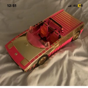 Leksaksbil lol Convertible - Snygg lol leksaksbil i rosa och guld med två säten och öppningsbart bagageutrymme. Bilen är i gott skick utan synliga skador eller slitage. Perfekt för Barbie-samlingen eller lekstunden. Färgglad design och fina detaljer på hjul och inredning.