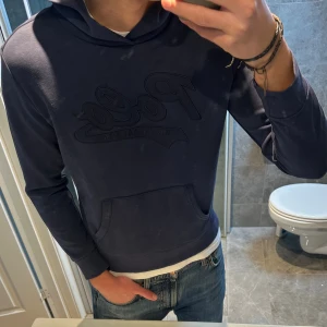 Mörkblå hoodie från Polo Ralph Lauren - Snygg mörkblå hoodie från Polo Ralph Lauren med broderad logga på bröstet. Hoodien är riktigt snygg och passar dig som bär S/xs. Finns inga defekter på tröjan. Hör av er vid funderingar/prisförslag:)
