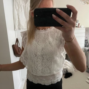 Vit spetstipp med volangdetaljer - Supersöt vit topp i spets från vila i jätte bra skick.