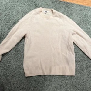 Beige kashmirtröja från Uniqlo XS - Mjuk och lyxig beige stickad tröja från Uniqlo i kashmir. Rund hals med ribbade muddar vid hals, ärmslut och nederkant. Perfekt för dig som gillar enkel och clean stil med premiumkänsla.