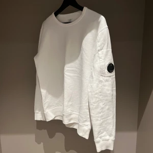 Vit sweatshirt från C.P. Company - Vit sweatshirt från C.P. Company med rund hals. Tillverkad i mjuk bomull för skön komfort. 