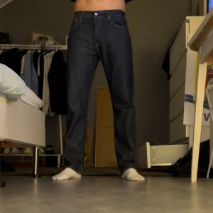 Levi's 501 mörkblå jeans straight fit - Säljer ett par klassiska Levi's 501 jeans i mörkblå tvätt med straight fit. Köpte dessa för knappt en månad sedan och har bara använt dom ett fåtal gånger (därav priset också) anledning till att jag säljer dom är för jag vill köpa en annan modell. Byxorna har fem fickor, knappgylf och det ikoniska läderpatchen bak i midjan. Perfekt passform och tidlös stil, tillverkade i slitstarkt jeanstyg.