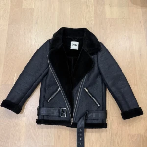 Zara vinterjacka  - Säljer en svart skinn/pälsjacka från Zara. Jackan är perfekt för kalla dagar. Stängs med sned dragkedja framtill och har en lite oversized look. Inga tecken på användning. 