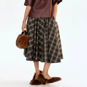 Ny cirkelskuren rutig kjol från H&M - En enkellång, cirkelskuren kjol i vävd bomull med ytbehandlat kantband i midjan. Kjolen har lös passform, diskreta sidfickor samt dold dragkedja med hyska och hake i ena sidan.  Färg: Grå Längd: Midi Midjehöjd: Normalhög midja (man kan ha den hängande på höften om man har en storlek större än sin normala) Kollektion: A/W 2025 HM 