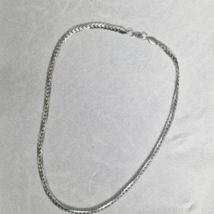 Silverfärgat Halsband i Rostfritt Stål – Tjock Kedja, Glansig & Hållbar | Unisex Smycke - Stilrent och glansigt halsband i rostfritt stål med rejäl kedja – perfekt för dig som gillar streetstyle eller clean mode. Tung, hållbar och elegant – funkar till både hoodie, skjorta och t-shirt. Färg: Silver  Material: Rostfritt stål (tål vatten & svett)  Design: Tjock glänsande kedja  Unisex – passar alla  Längd: Medium     I mycket fint skick, utan repor.  Rengjord och redo att användas.  Öppen för bud