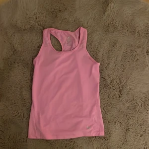 Rosa linnetopp från SOC - Säljer en sportig rosa linnetopp från SOC med meshpaneler på ryggen för extra ventilation. Toppen är ärmlös och har en racerback-design som ger grym rörelsefrihet. Perfekt för träning och aktiva dagar. Materialet är lätt och syntetiskt för att hålla dig sval.