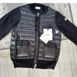Svart dunväst med fickor och dragkedja - Säljer min jätte snygga monclear cardigan den ser helt ny ut och aldrig använd 💕