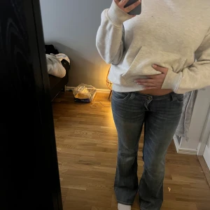 Blå bootcut jeans från Cheap Monday - Snygga blå jeans från Cheap Monday med bootcut passform och låg midja. Klassisk femficksmodell med coolt Cheap Monday-märke bak i svart och vitt. Jeansen är i denim och har en lätt tvättad look som ger en avslappnad vibe. Etiketten är lite sliten men det påverkar absolut inte, skit snygga hade väldigt gärna behållt om de inte varit för stora.