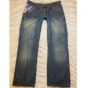 Lågmidjade jeans från I.CODE - Snygga blå jeans från I.CODE blommigt mönster. De ör bootcut/ raka i modellen och har låg midja. Står ej storlek men skulle säga att de passar strl S/M.