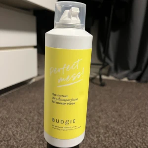 Torrschampo i skumformat  - Budgie Perfect Mess är ett torrschampo i skumformat som ger textur och volym till håret. Flaskan är vit med en ljusgul etikett och har en praktisk pump. Produkten har en fräsch doft av persika och är 100% vegansk. 