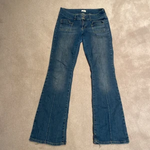 Blå bootcut jeans EU 40 - Snygga blå bootcut jeans med klassiska fickor fram och bak. Slitningar längs ner på benen som syns på bilden, är även lagade på kemtvätt mellan bena men inget som syns! 