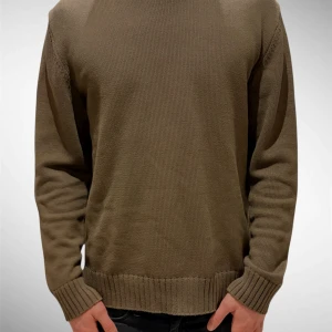 Olivgrön stickad tröja  - Tvärsnygg olivgrön stickad tröja från PrettyGreen i stl L. Inga defekter alls, som ny. Materialet är mjukt och skönt mot huden. Perfekt passform för den som normalt bär L. Hör av dig vid frågor :) Modellen på bilden är 189, väger 78.