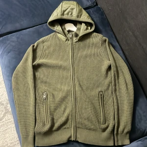 Mörkgrön Indicode cardigan - Säljer en fet mörkgrön Indicode cardigan som är hyfsat svår att få tag på i storlek XS men den passar mer som S. Cardiganen är i ny skick. Perfekt för denna hösten. Om ni har några funderingar är de bara att skriva till mig så återkommer jag. Jag tar även emot byten om de skulle vara så