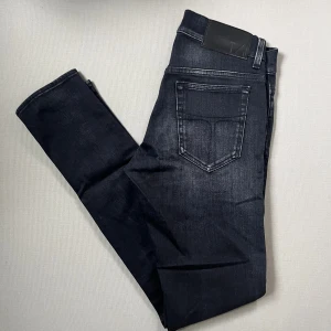 Tiger of Sweden slim jeans - Svarta Tiger of Sweden slim fit jeans, tillverkade i Italien. Klassisk femficksmodell med snygga kontrastsömmar och diskret tvättad look. Perfekta för dig som gillar en smalare passform och stilren design.