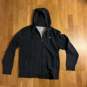Blå hoodie från Lacoste  - Blå fet hoodie i bra skick från Lacoste. Priset kan diskuteras. L men sitter som M