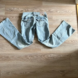 Ljusblå bootcut jeans från True Religion - Säljer ett par ljusblå jeans från True Religion med bootcut passform. Säljer dessa då jag råka köpa fel storlek Storleken är w27. 